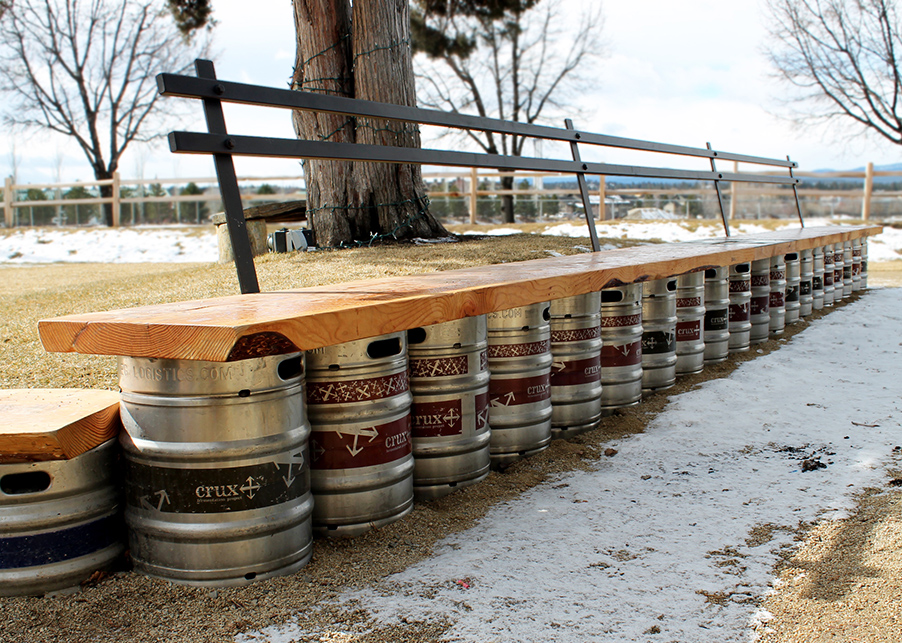 Custom bench seating in the courtyard designed using old kegs, cedar planks, and iron backings.